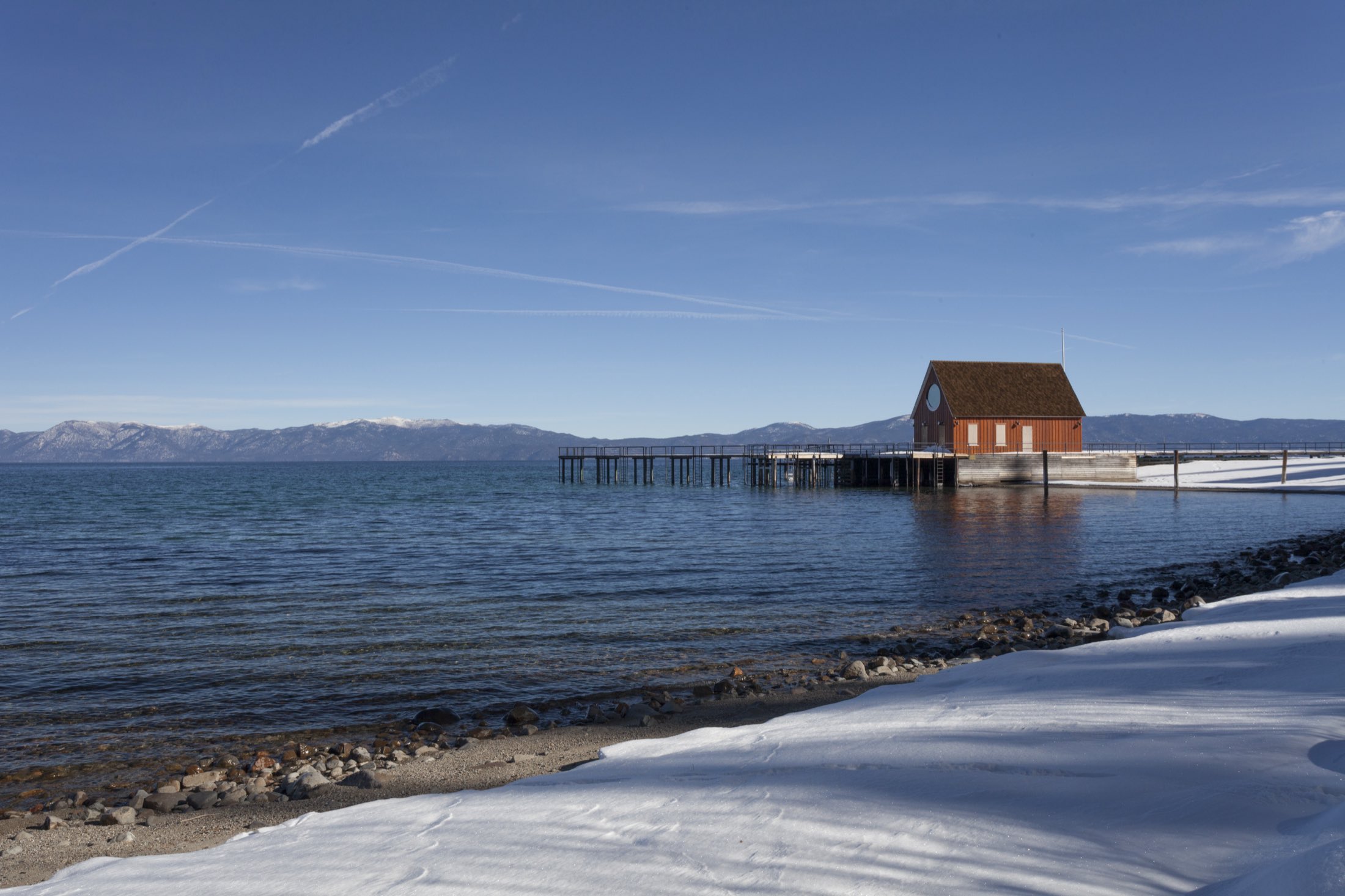 A pier and boathouse on the snow-lined West Shore of Lake Tahoe